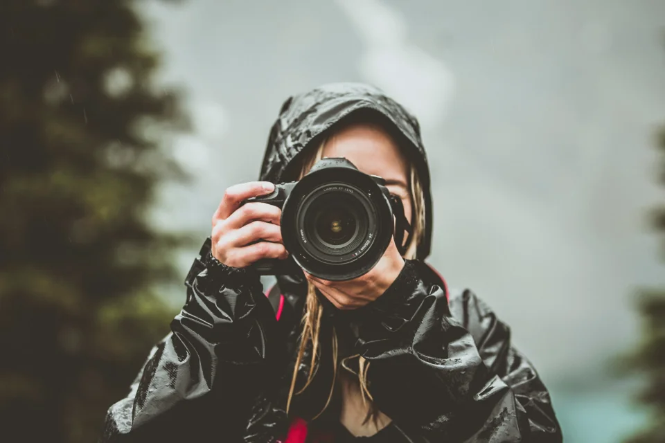 Photographer cầm máy ảnh chụp ngoài trời