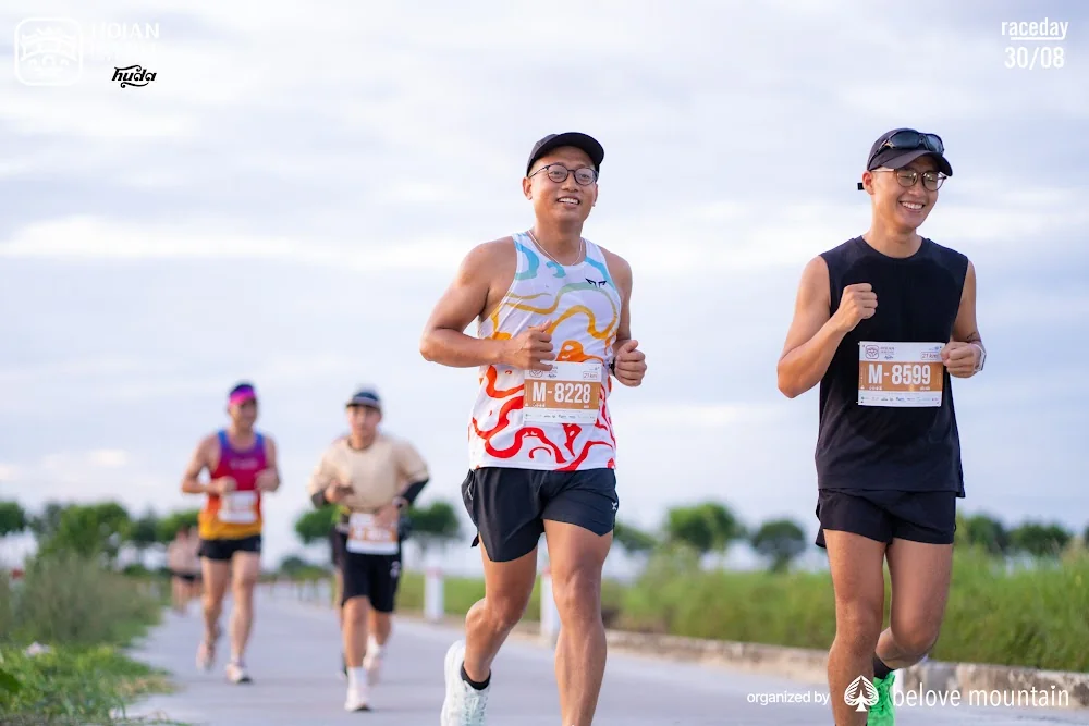 Hai runner đeo số BIB, khuôn mặt rõ trên đường chạy Hội An